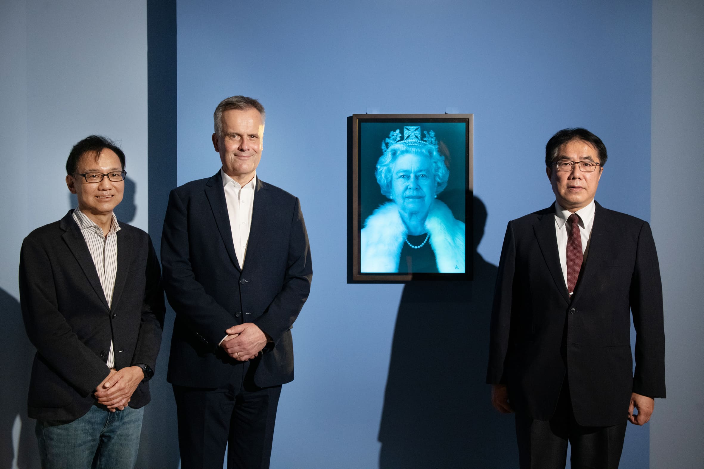 英國在台辦事處代表鄧元翰（中）與台南市長黃偉哲（右）、奇美博物館館長許家彰（左）一同欣賞《時代的臉孔》國際大展，並與女王伊莉莎白二世的肖像合影。